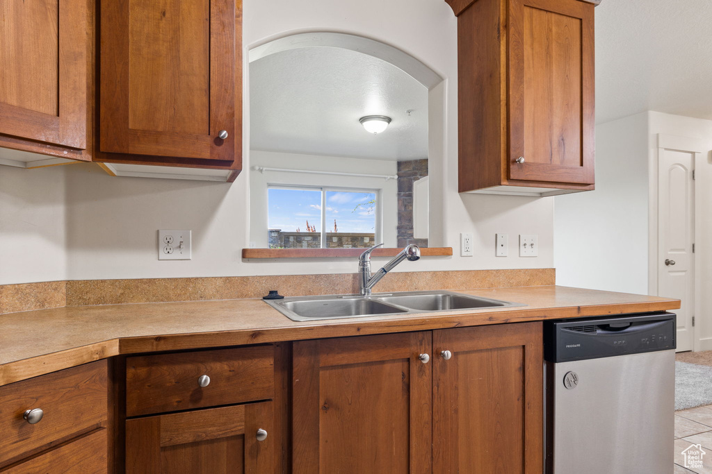 Kitchen with tile patterned floors, sink, and dishwasher