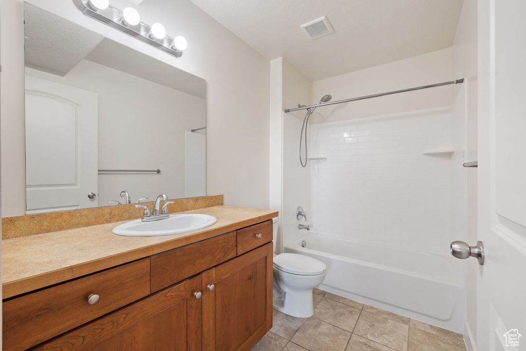 Full bathroom with tile patterned floors, vanity, shower / bath combination, and toilet