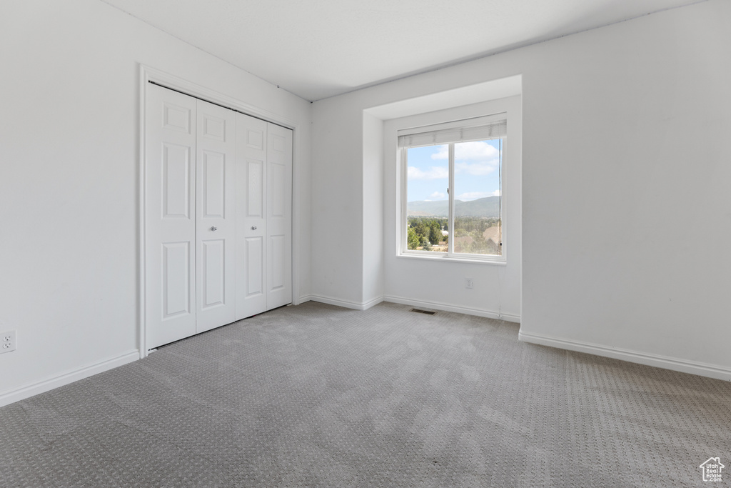 Unfurnished bedroom featuring a closet and carpet