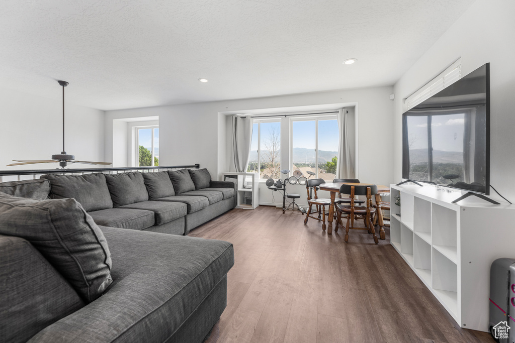 Living room with ceiling fan and dark hardwood / wood-style floors