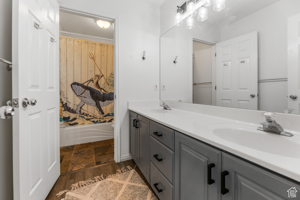 Bathroom with tile patterned floors, dual vanity, and a bath