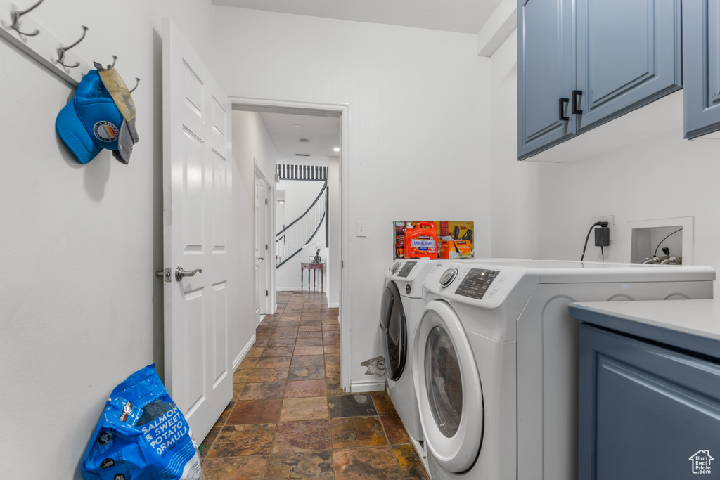 Laundry room featuring cabinets, separate washer and dryer, and dark tile patterned flooring