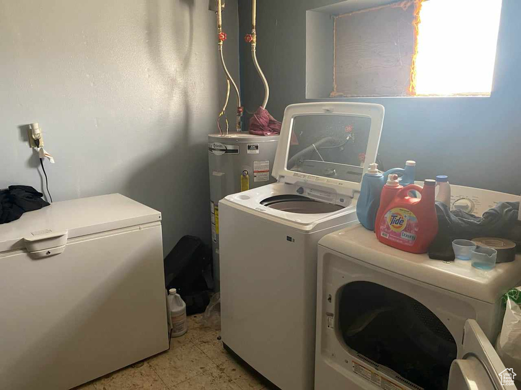 Clothes washing area with electric water heater, washing machine and clothes dryer, and light tile patterned floors