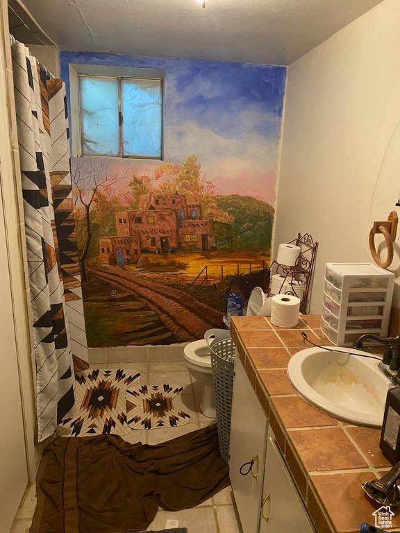 Bathroom with vanity, tile patterned floors, and toilet