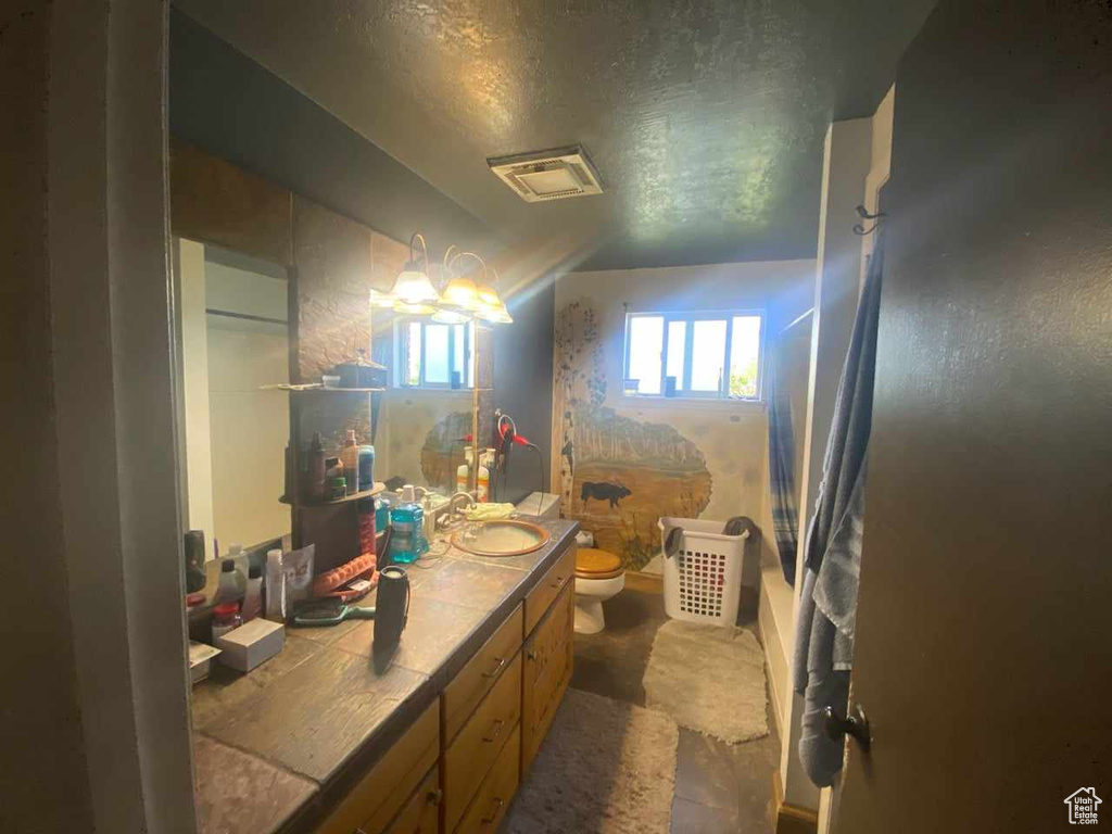 Bathroom with vanity, toilet, and a textured ceiling