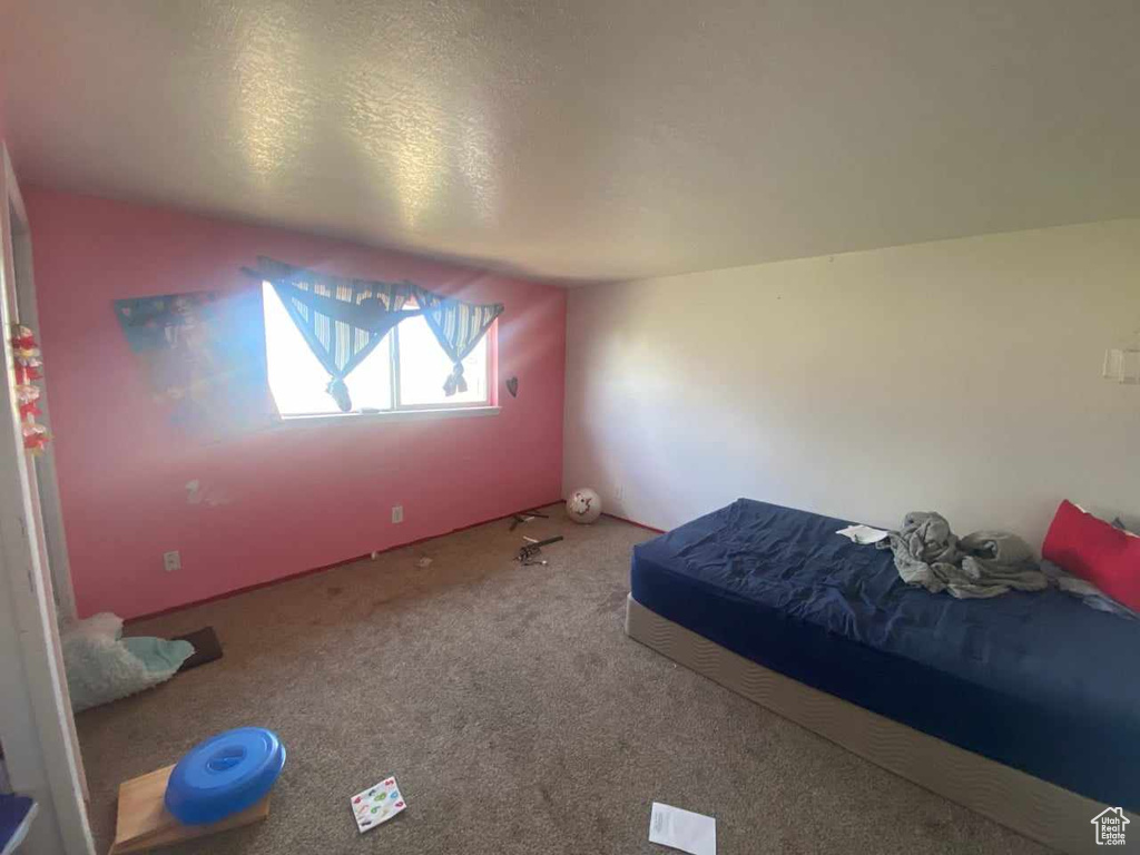 Unfurnished bedroom with carpet and a textured ceiling