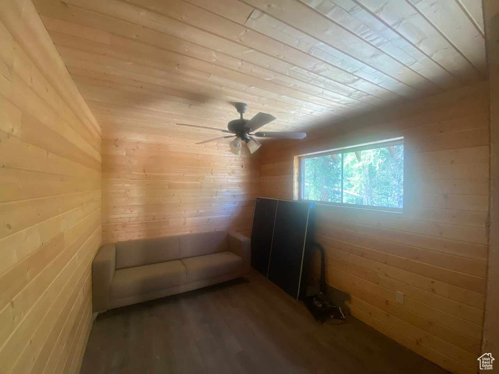 Interior space with wood walls, wooden ceiling, and ceiling fan