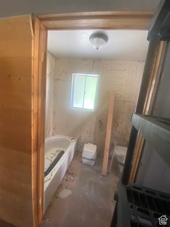 Bathroom with concrete flooring and a bath