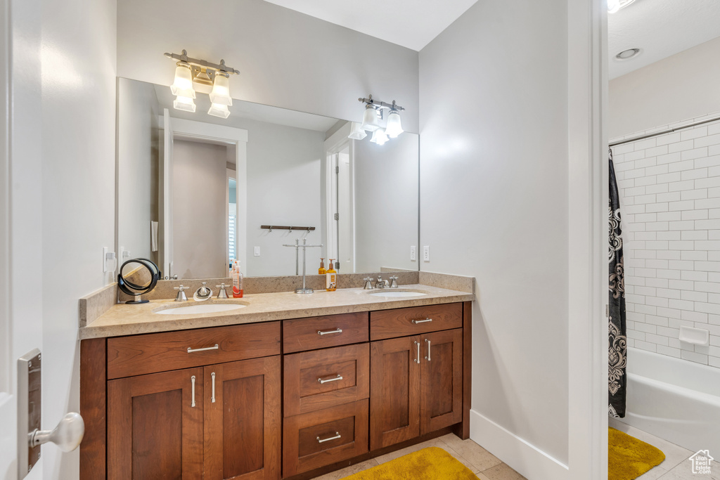 Bathroom with double vanity, tile patterned flooring, and shower / bath combination with curtain