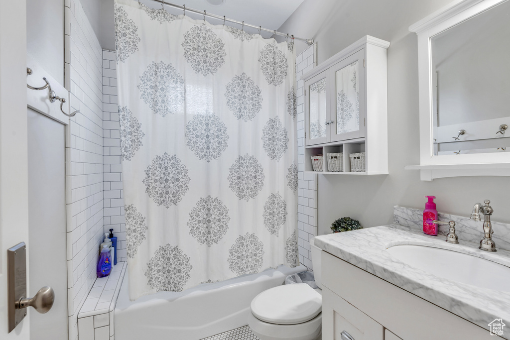 Full bathroom featuring vanity, toilet, and shower / bath combination with curtain