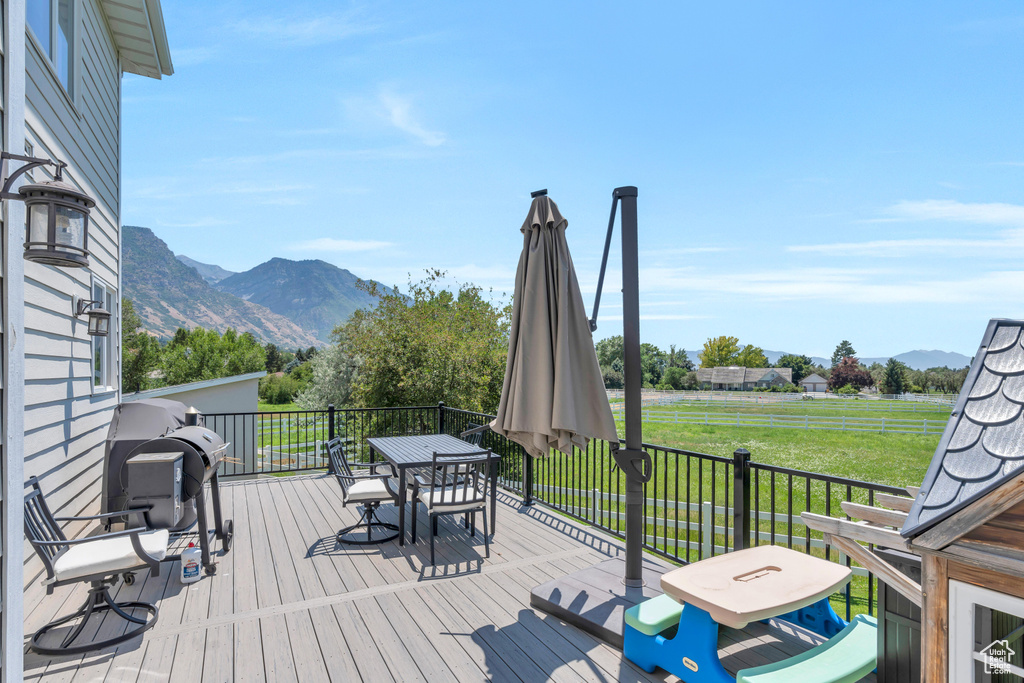 Wooden terrace featuring a mountain view and a yard