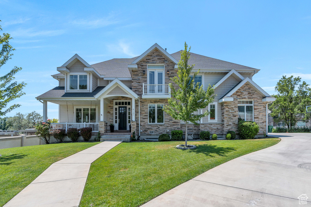 Craftsman house with a porch, a balcony, and a front yard