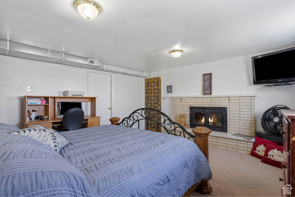 Carpeted bedroom featuring a brick fireplace