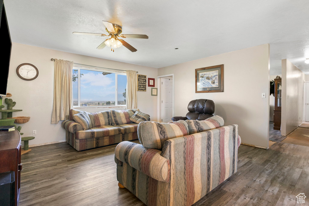 Living room with dark hardwood / wood-style floors and ceiling fan