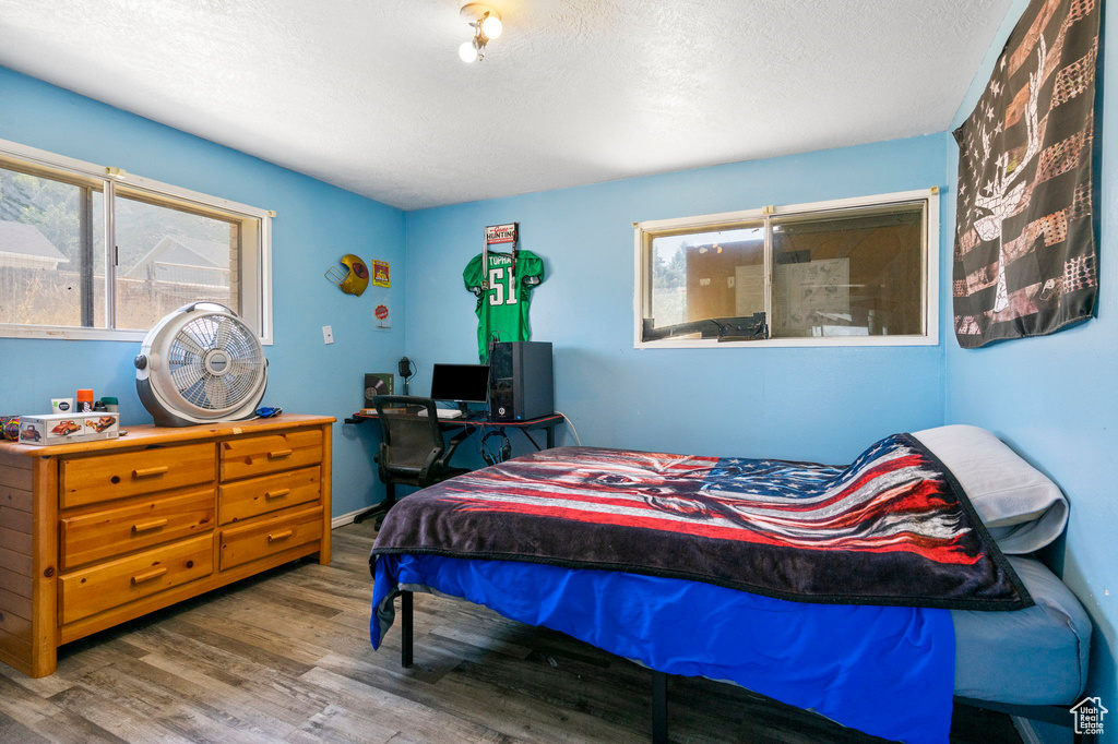 Bedroom with a textured ceiling and hardwood / wood-style flooring