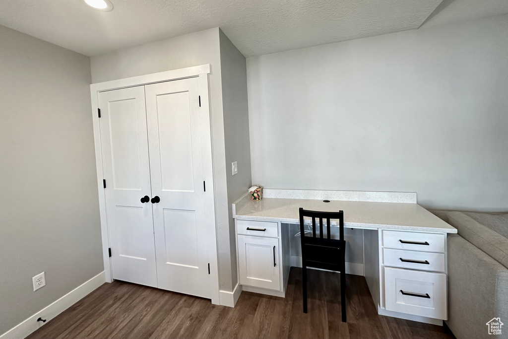 Office space with dark hardwood / wood-style floors