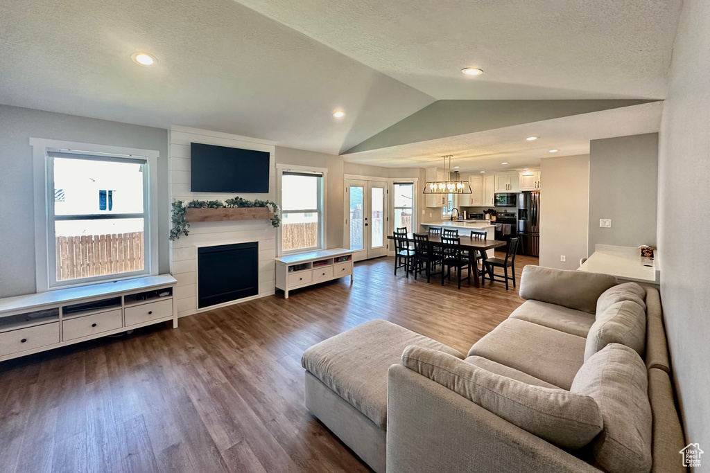 Living room featuring sink, a chandelier, dark hardwood / wood-style flooring, and vaulted ceiling