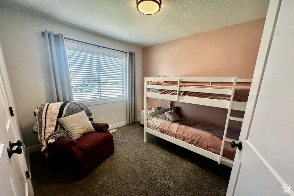 Bedroom featuring carpet and a textured ceiling