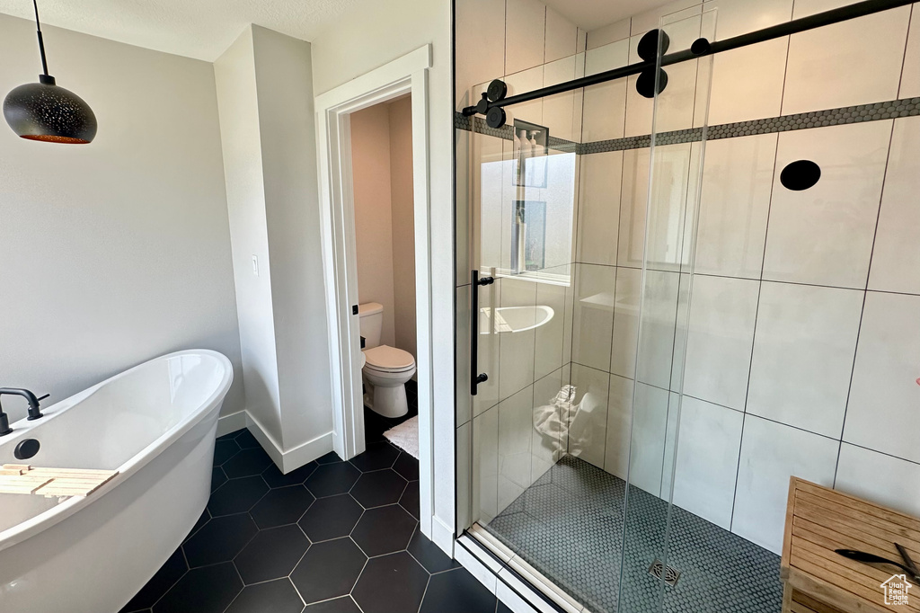 Bathroom with independent shower and bath, toilet, tile patterned flooring, and tile walls