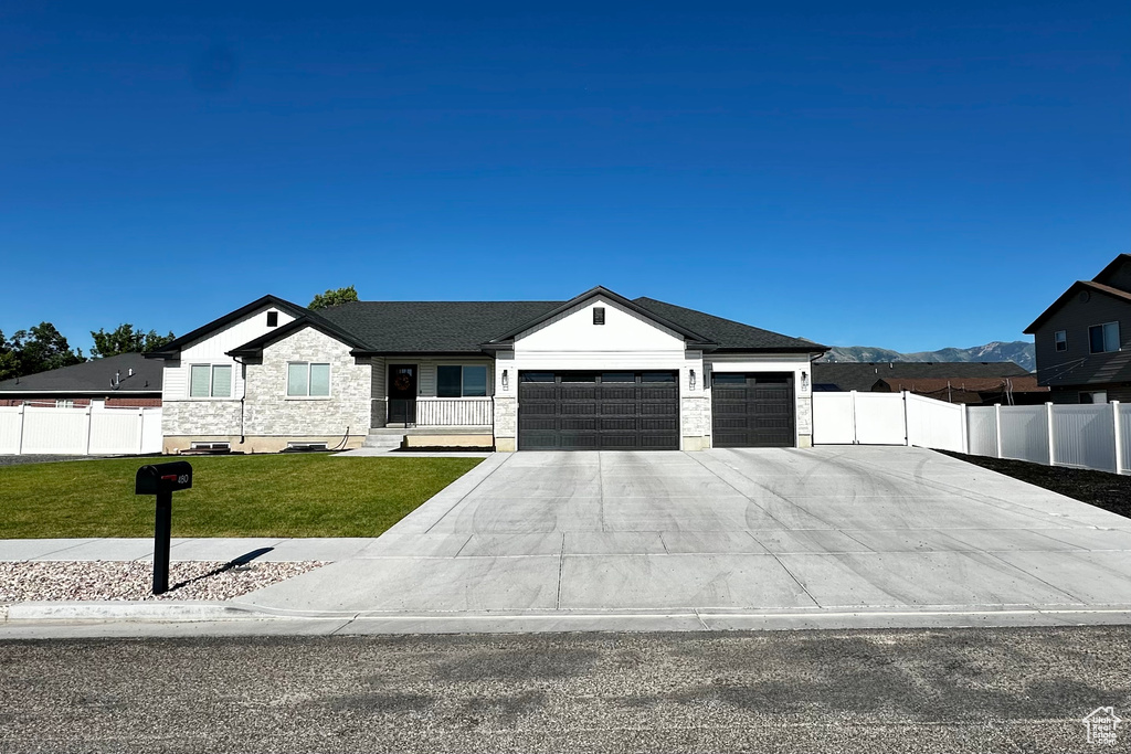 View of front facade featuring a garage and a front yard