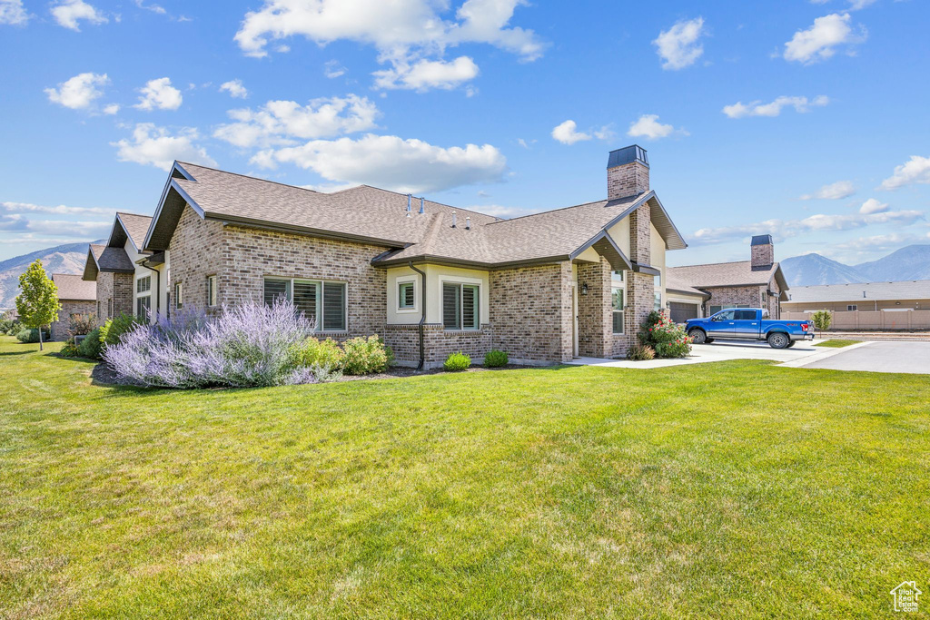 View of front of house featuring a front lawn and a mountain view