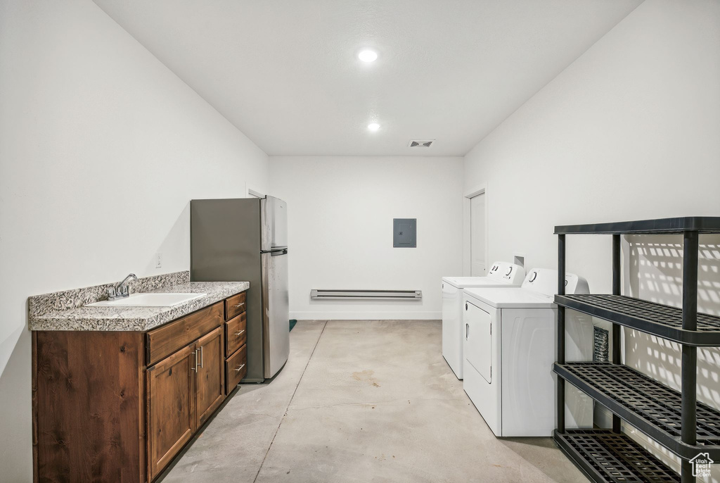 Washroom featuring washer and clothes dryer, sink, baseboard heating, and electric panel