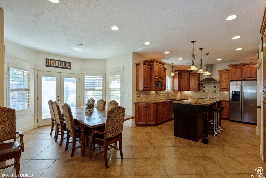 Dining room featuring sink, light tile patterned flooring, and french doors