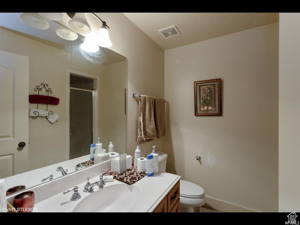 Bathroom featuring tile patterned flooring, toilet, and vanity