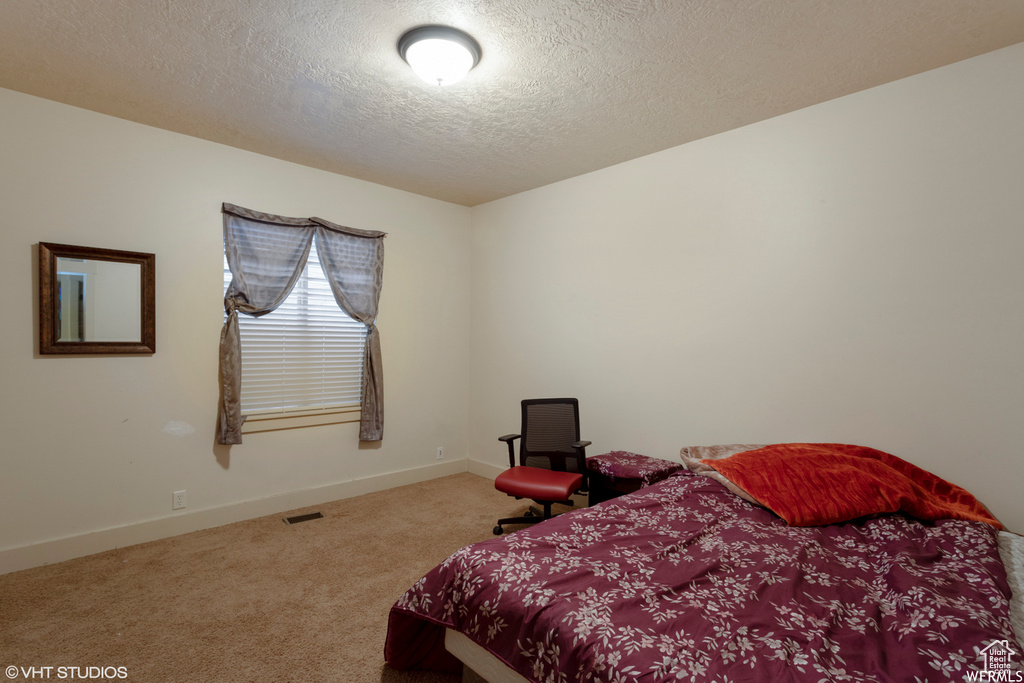 Bedroom with carpet floors and a textured ceiling