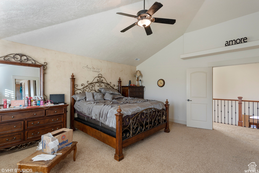 Carpeted bedroom featuring a textured ceiling, ceiling fan, and lofted ceiling