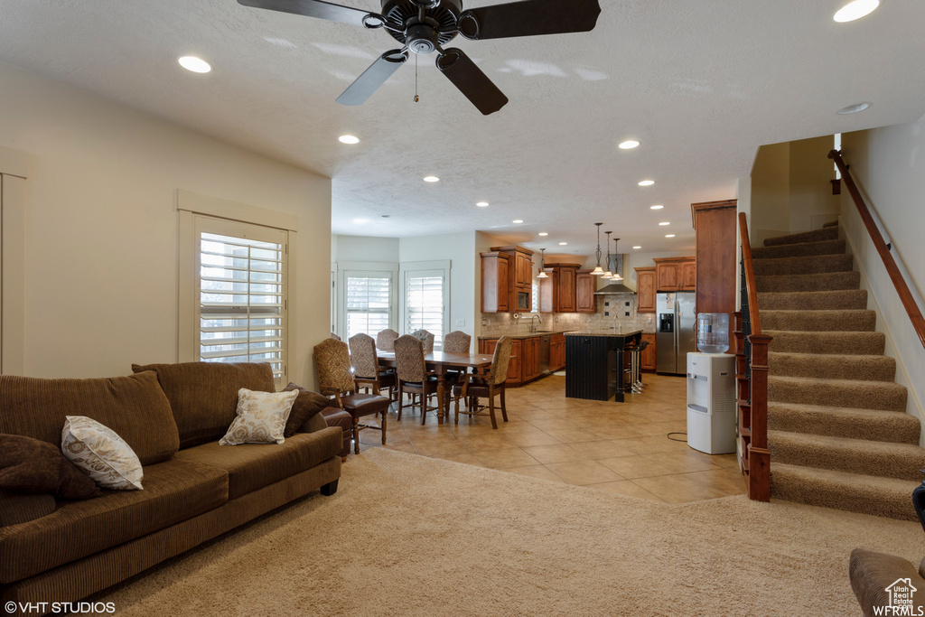 Carpeted living room with ceiling fan