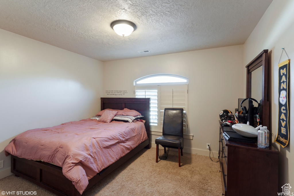 Carpeted bedroom featuring a textured ceiling