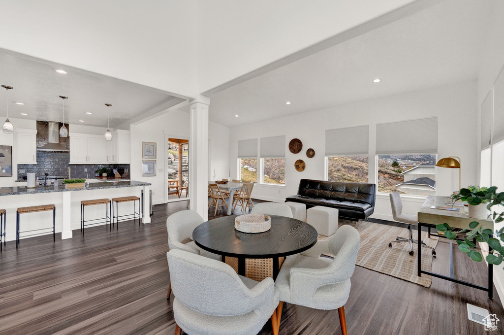 Dining area with dark hardwood / wood-style floors and ornate columns