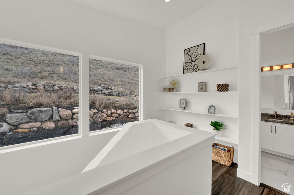 Bathroom with built in features, vanity, and hardwood / wood-style flooring