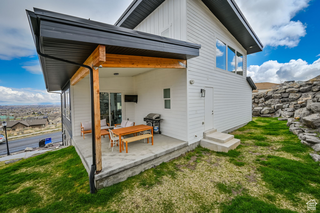 Rear view of house featuring a patio area and a lawn