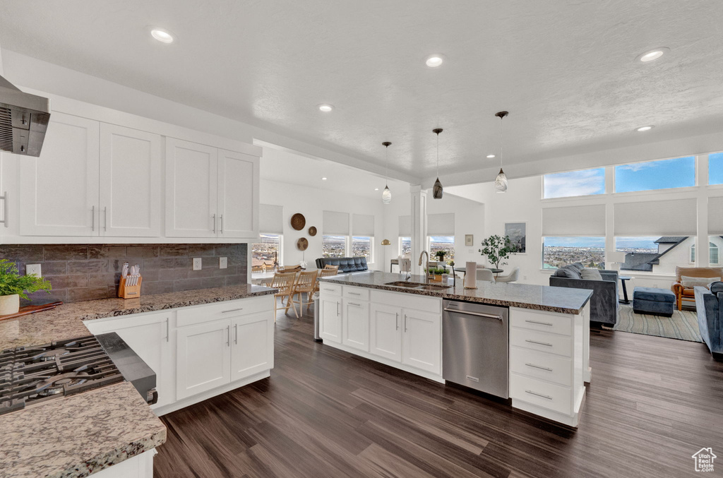 Kitchen featuring dishwasher, dark hardwood / wood-style floors, tasteful backsplash, and decorative light fixtures