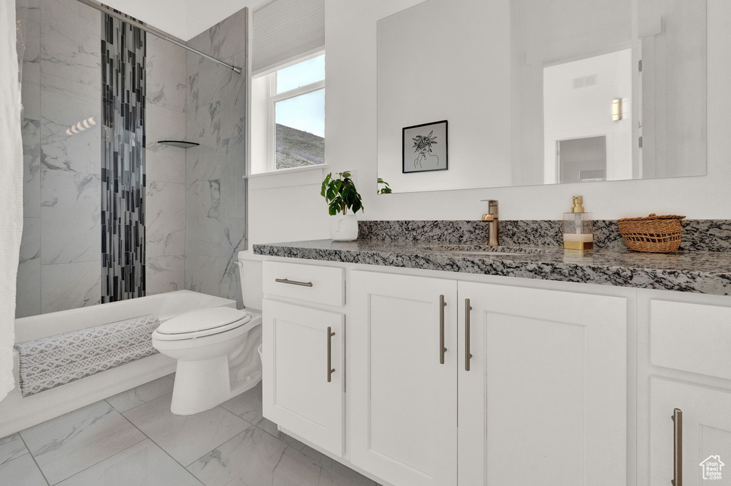 Full bathroom with shower / tub combo with curtain, vanity, tile patterned flooring, and toilet