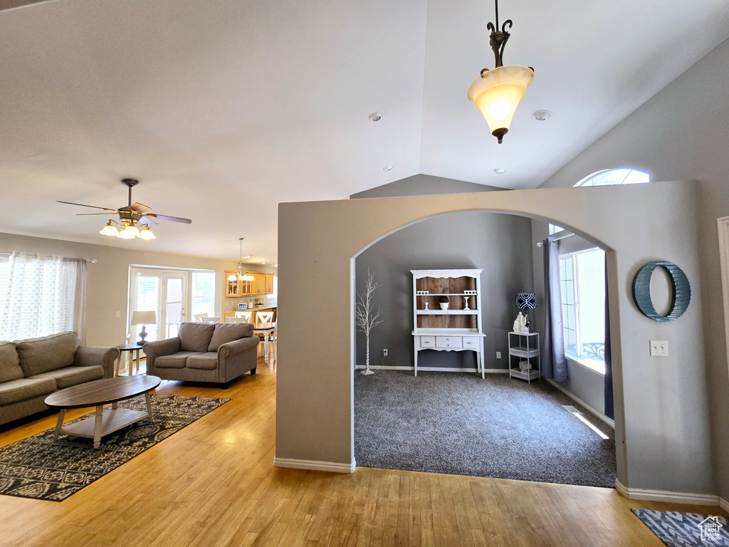 Carpeted living room featuring lofted ceiling and ceiling fan