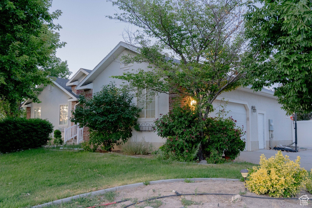 View of property exterior with a garage and a lawn