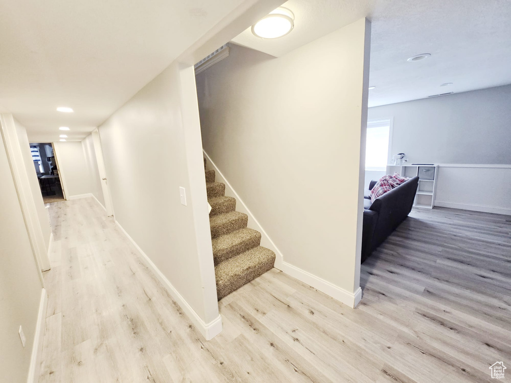 Stairway with light hardwood / wood-style flooring