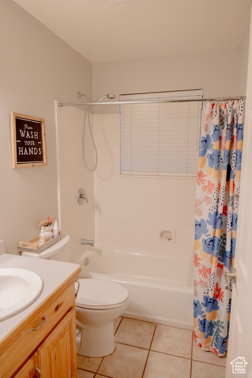 Full bathroom with tile patterned flooring, toilet, vanity, and shower / tub combo with curtain