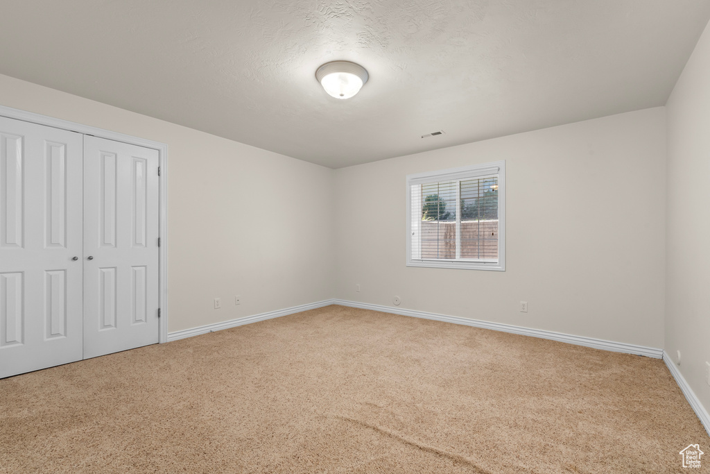 Unfurnished bedroom featuring a closet and carpet flooring