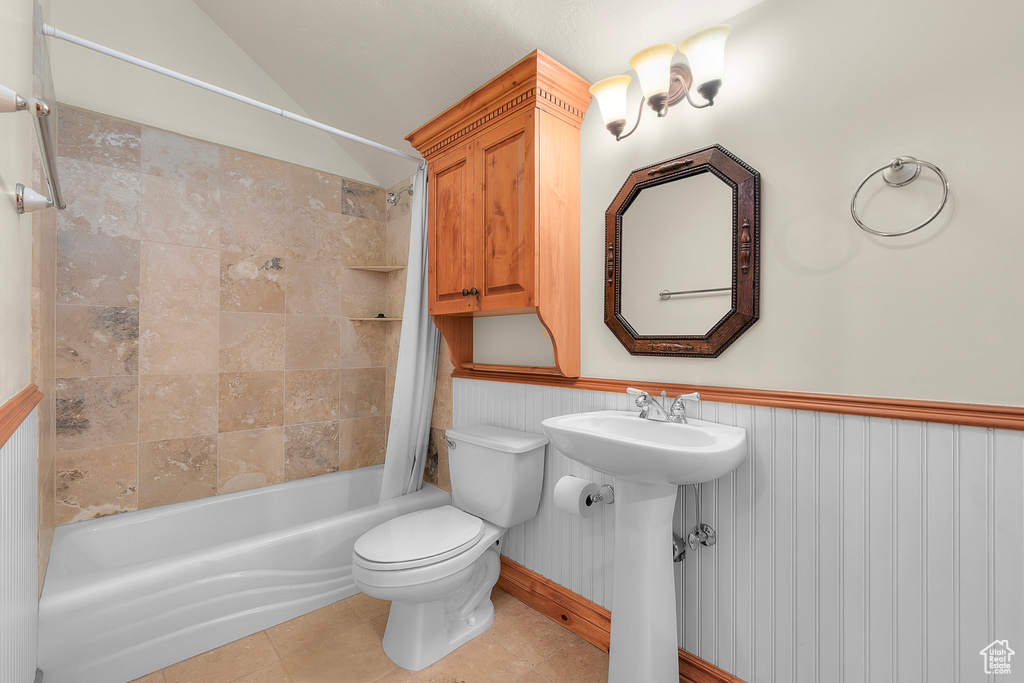 Full bathroom featuring shower / bath combo with shower curtain, tile patterned floors, toilet, and sink