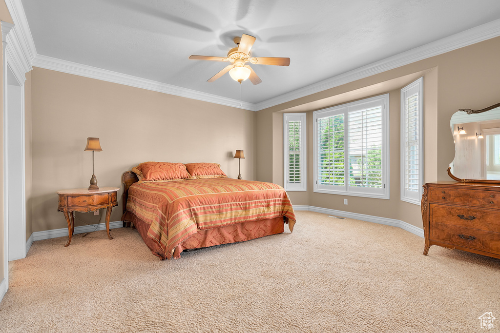 Carpeted bedroom with crown molding and ceiling fan