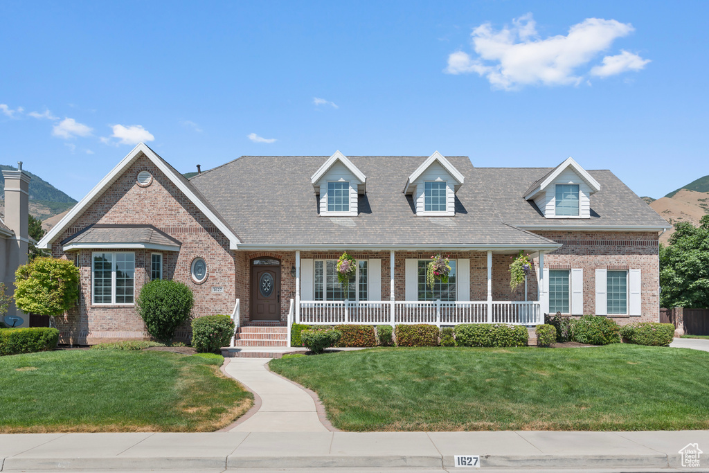 Cape cod home featuring a front yard