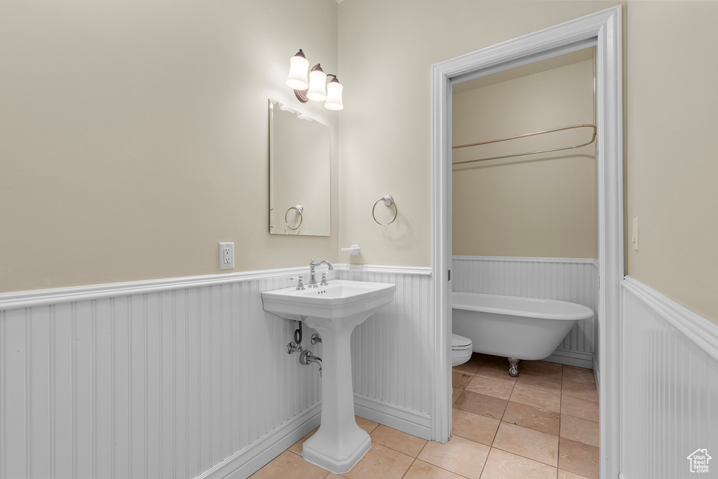 Bathroom with toilet, tile patterned floors, and a bathing tub