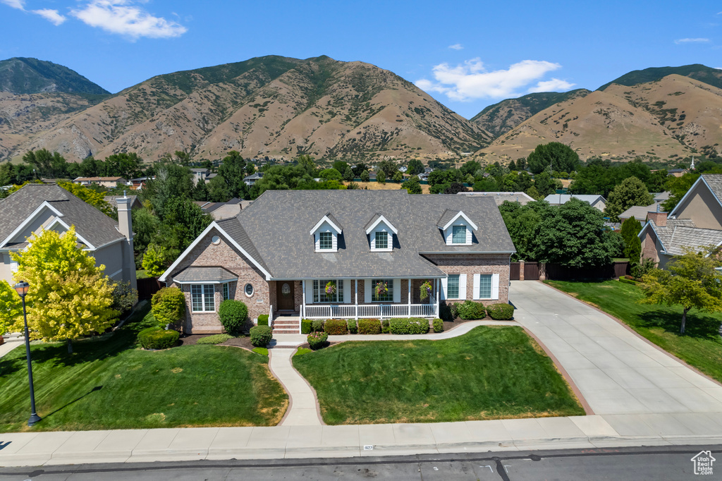 View of front facade featuring a mountain view and a front yard