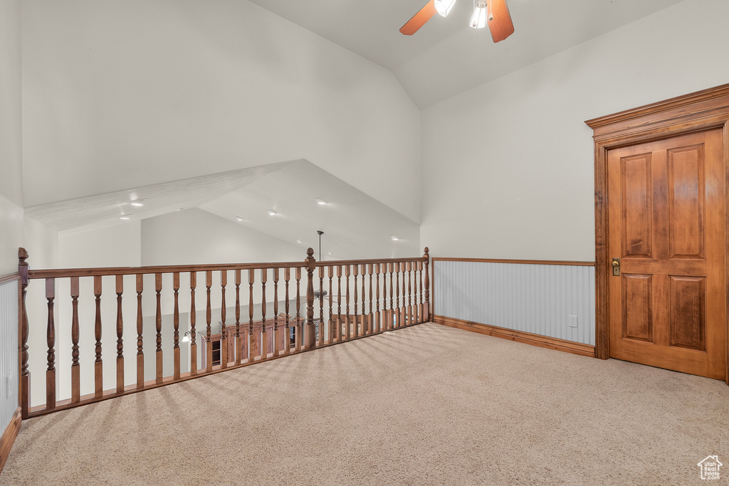 Spare room featuring lofted ceiling, carpet, and ceiling fan