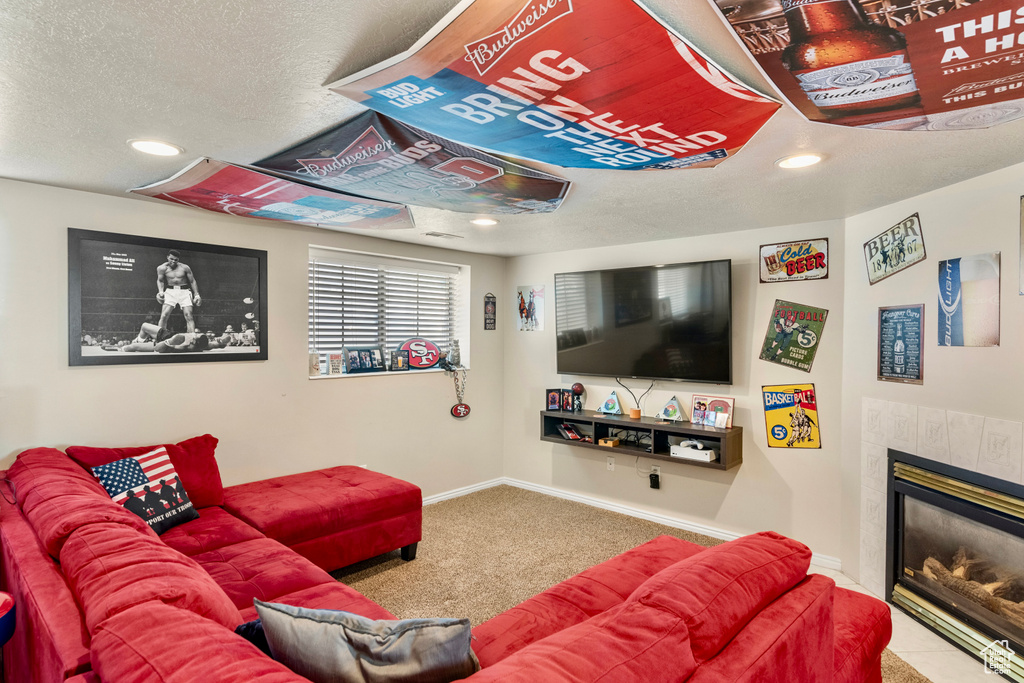 Carpeted living room featuring a fireplace and a textured ceiling