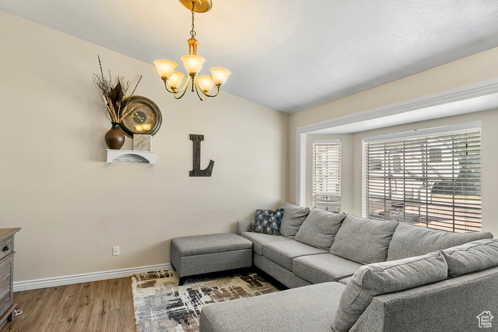 Living room with a notable chandelier and hardwood / wood-style floors